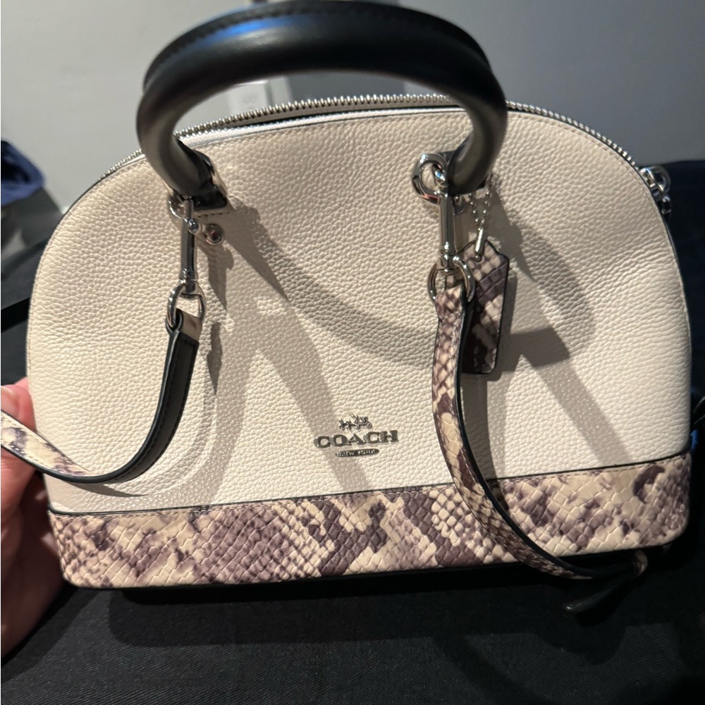 Coach crossbody bag with animal print trim on the bottom and strap.